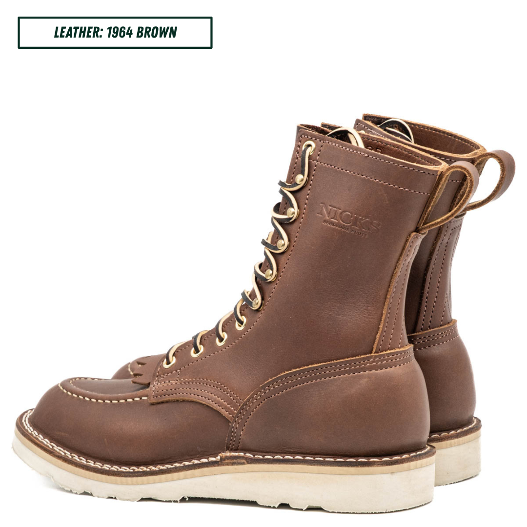 Moctoepro boots, both sitting together facing back left. Label on top left corner that reads "LEATHER: 1964 BROWN."