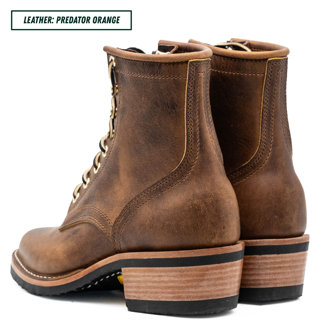 A pair of distressed brown leather lace-up ankle boots with stacked wood-look heels, shown from a three-quarter rear angle on a white background. A text label in the top-left corner reads 'LEATHER: PREDATOR ORANGE'.