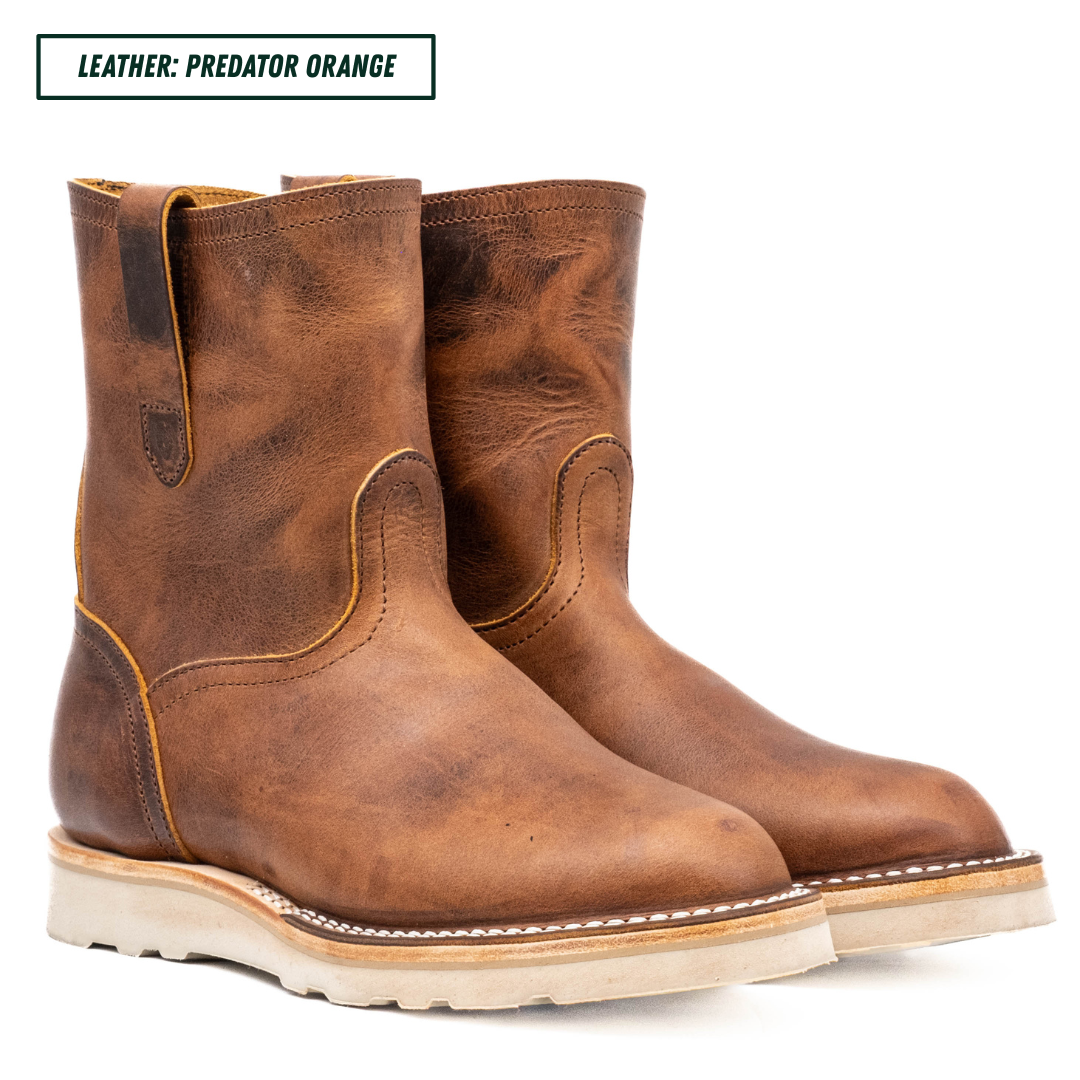 A pair of distressed brown leather mid-calf boots with light tan soles, shown on a white background with a text label in the top left corner that reads 'LEATHER: PREDATOR ORANGE'.