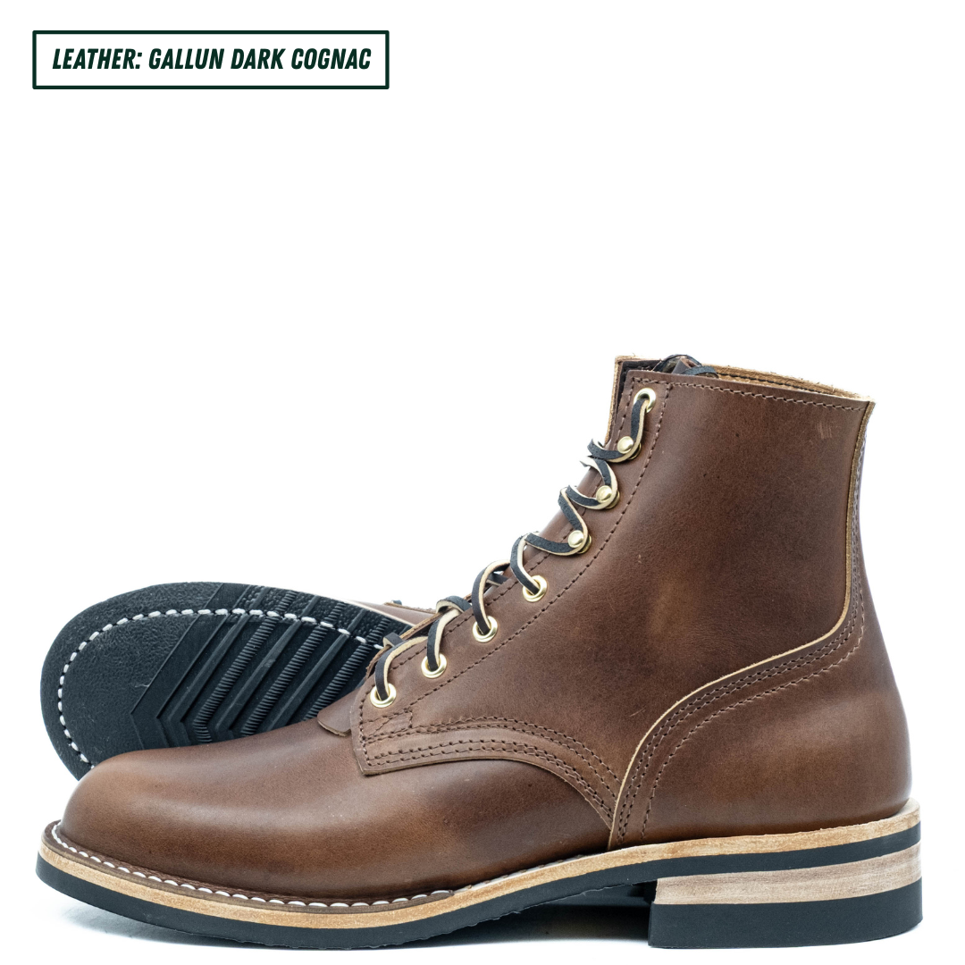 A pair of dark cognac brown leather lace-up boots, with one boot standing upright and the other lying on its side to show the treaded black sole. A text label in the top left corner reads 'LEATHER: GALLUN DARK COGNAC'.