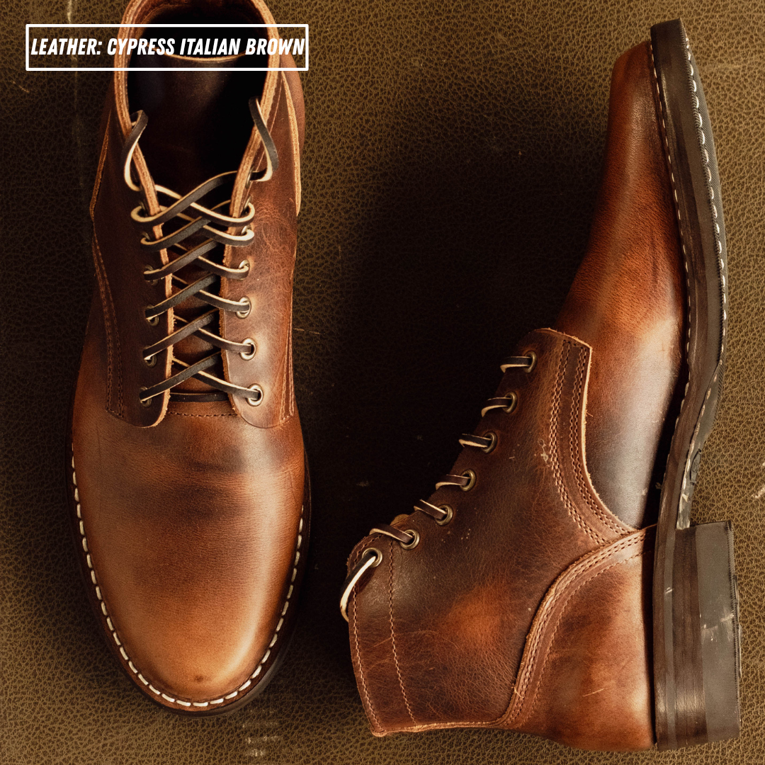 Two brown leather lace-up boots shown on a textured brown background, with one boot upright and the other angled to show the side and heel. Text in the top left reads 'LEATHER: CYPRESS ITALIAN BROWN'.