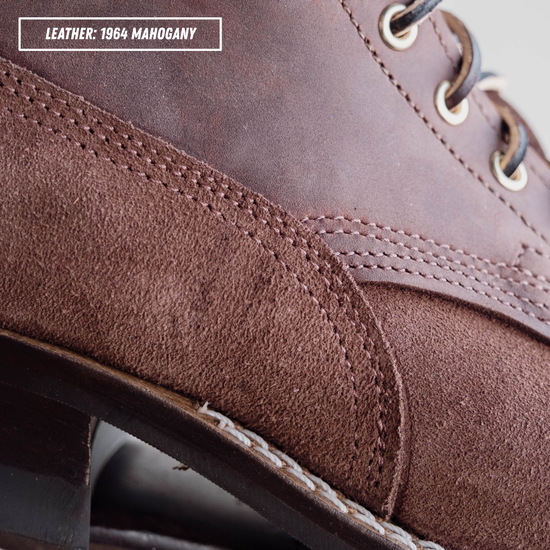 Close-up of a brown leather shoe showing the grain and suede-like texture, with metal eyelets and laces. A text label in the top left reads 'LEATHER: 1964 MAHOGANY'.