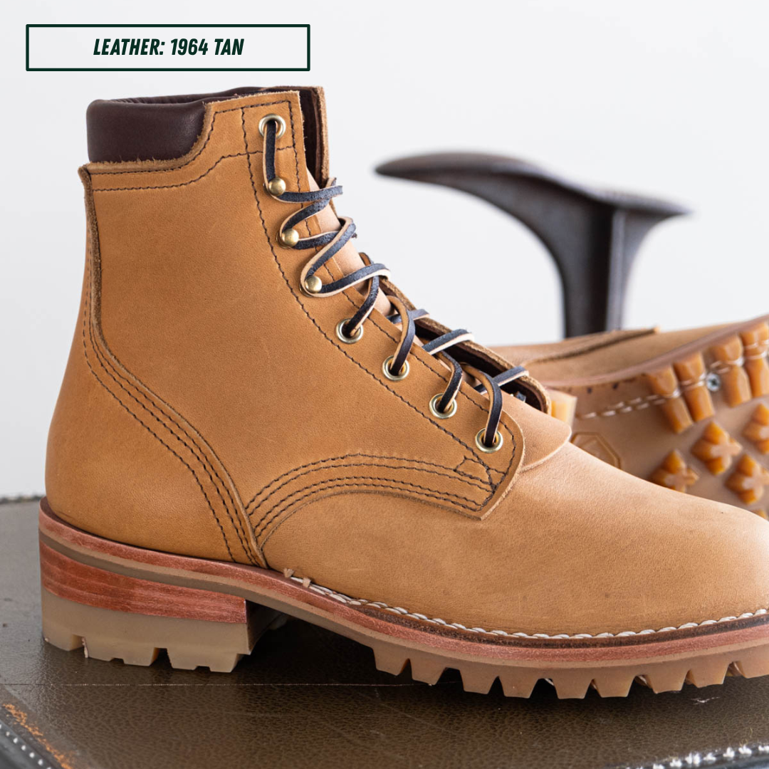 A tan leather lace-up boot shown in a close-up studio-style product photo, with part of a second boot visible behind it and a text label reading 'LEATHER: 1964 TAN' in the top left.