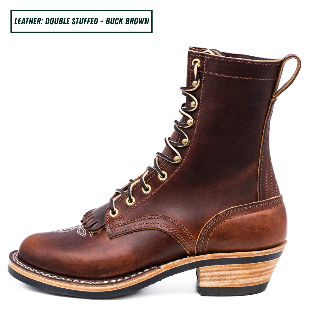 A brown double-stuffed leather lace-up boot with a stacked wood-look heel, shown in profile on a white background. A text label in the top-left corner reads 'LEATHER: DOUBLE STUFFED - BUCK BROWN'.
