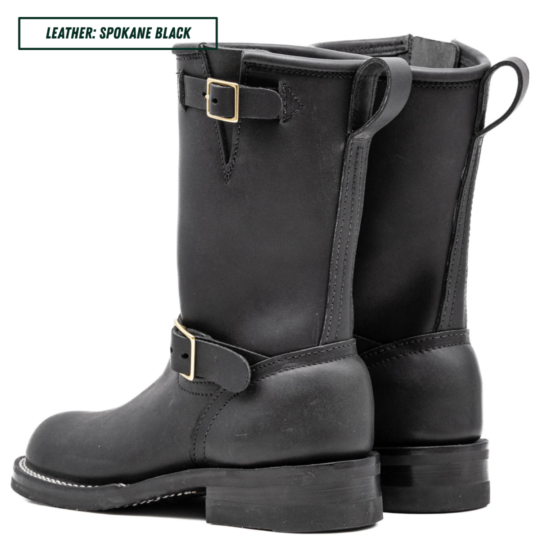 A pair of black leather mid-calf boots with buckle straps, shown from the side and back on a white background. A text label in the top-left corner reads 'LEATHER: SPOKANE BLACK'.