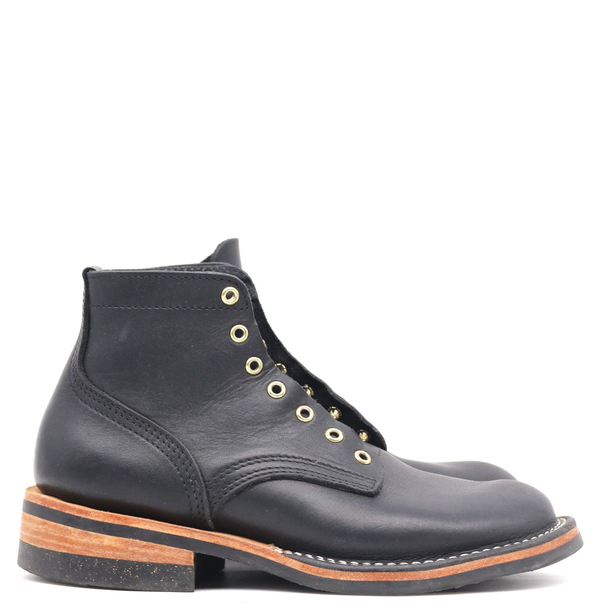 A single black leather ankle boot with gold-tone metal eyelets and a stacked black and brown sole, shown from a side profile on a white background.
