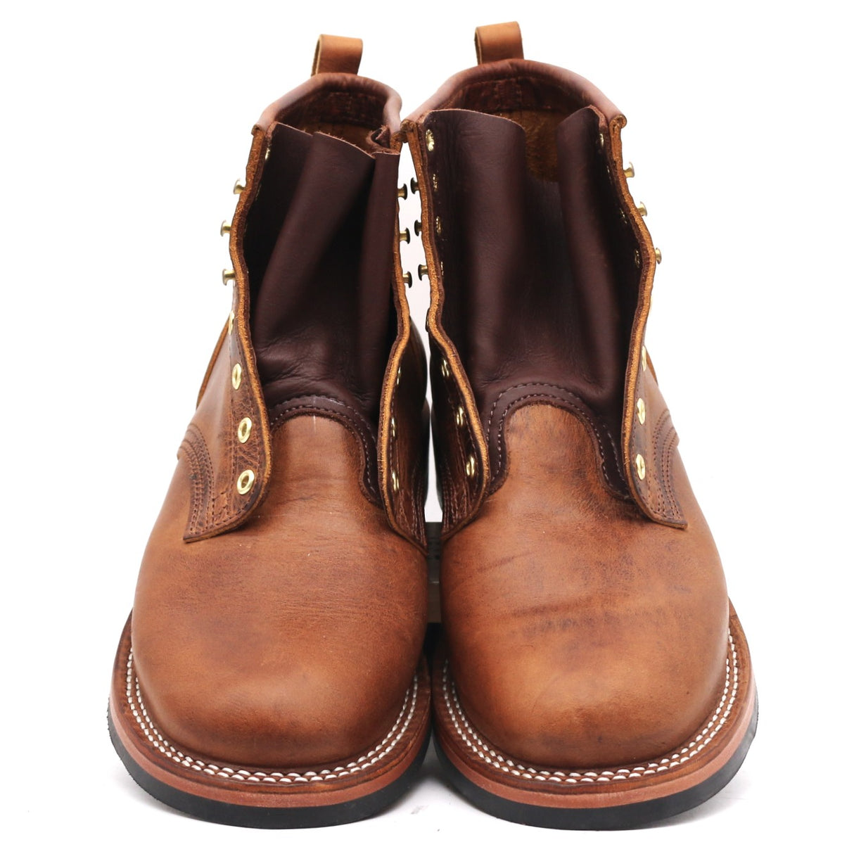 A pair of brown leather lace-up ankle boots with gold-tone eyelets and white contrast stitching, photographed against a plain white background.