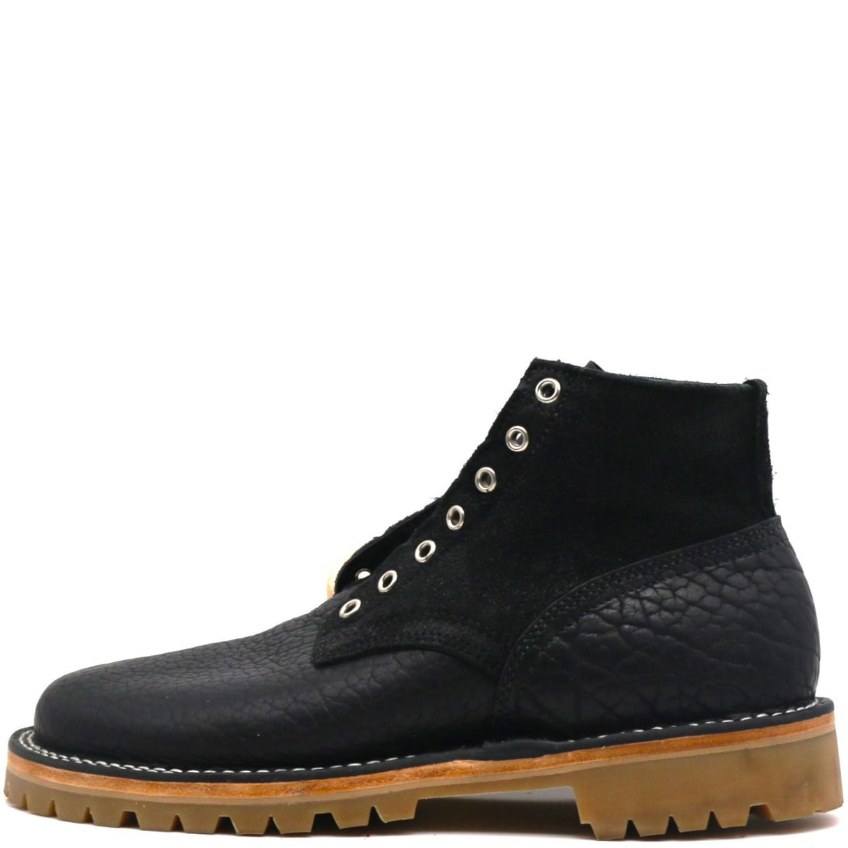 A black ankle boot with a textured leather upper, silver metal eyelets, and a tan lug sole, shown from a side profile on a white background.
