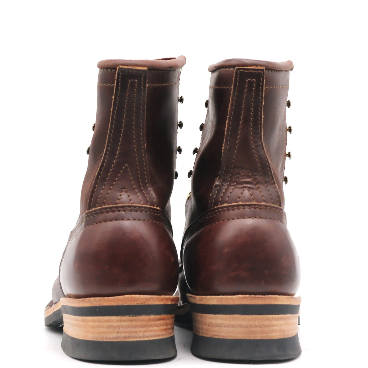 A pair of dark brown leather lace-up ankle boots shown from the back, featuring a stacked sole with a black rubber toe cap, a tan midsole, and a black outsole, set against a plain white background.