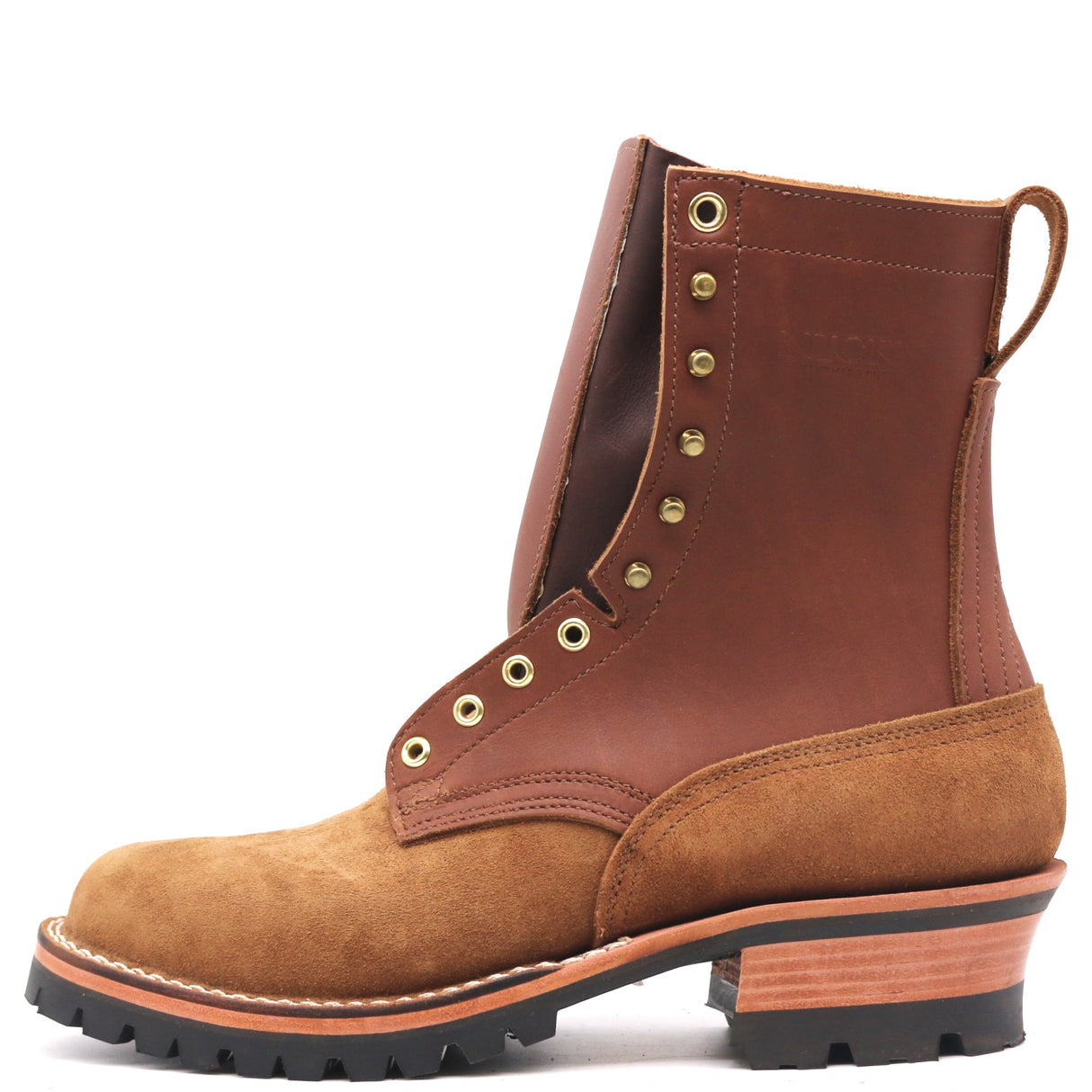 A rugged ankle boot made of brown leather and tan suede, featuring brass eyelets, a stacked wood-look heel, and a black lug sole, shown from a side profile on a white background.