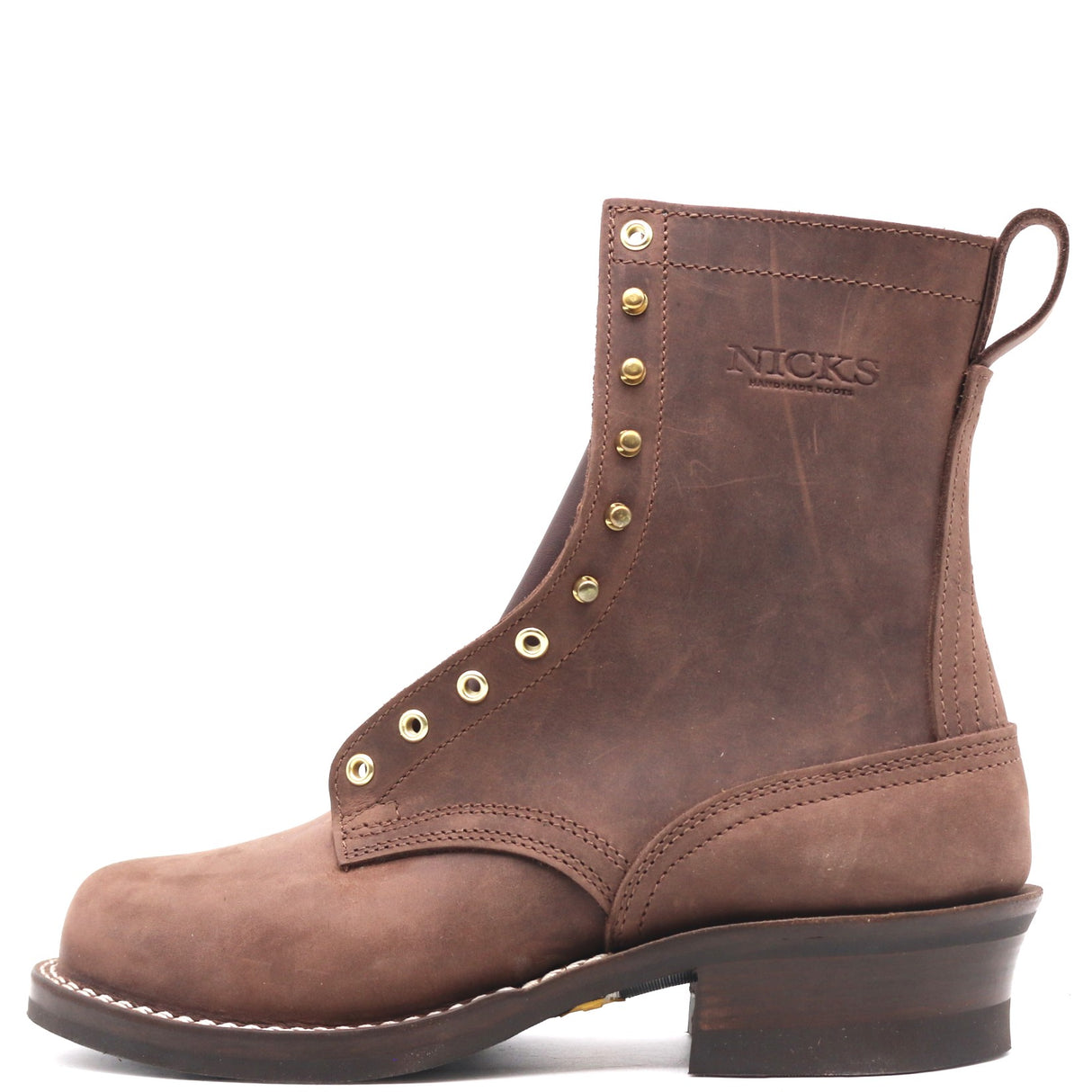 A brown leather lace-up ankle boot with brass eyelets, a pull tab, and 'NICKS' embossed on the side, shown against a plain white background.