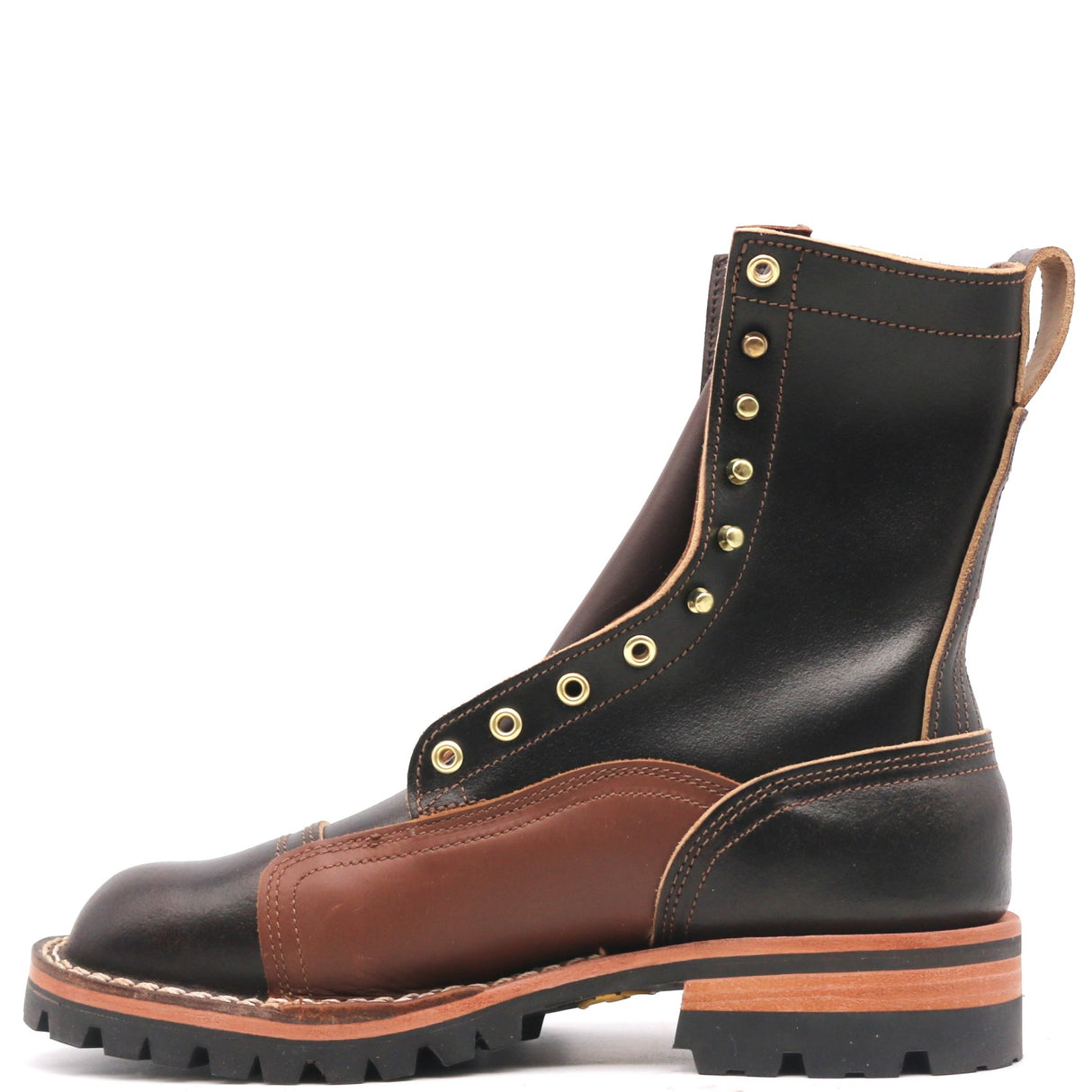 A rugged lace-up leather boot in black and brown, featuring brass eyelets, a thick black lug sole, and contrast stitching, shown from a side profile on a white background.