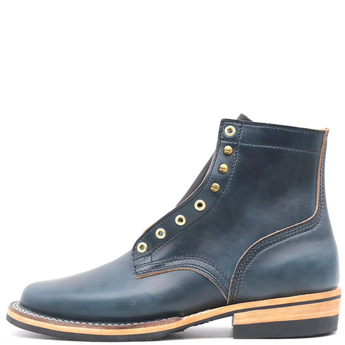 A dark blue leather ankle boot with gold-tone metal eyelets and studs, a light tan midsole, and a black outsole, shown from a side profile on a white background.