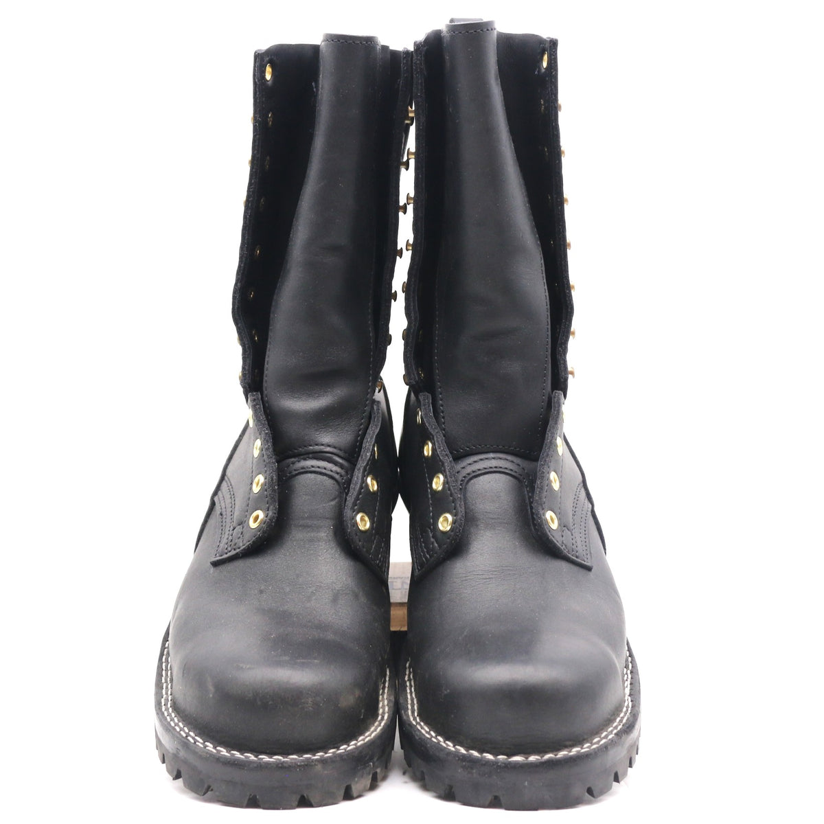 A pair of black leather mid-calf boots with gold-tone metal studs and eyelets, shown from the front against a plain white background.