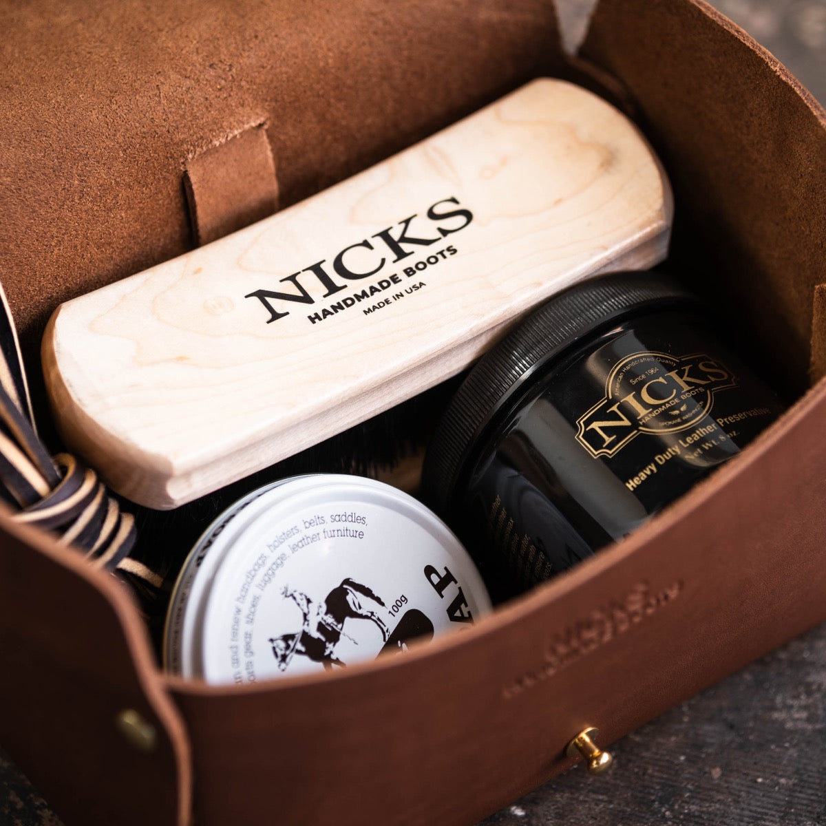 Leather Box filled with leather care brush, leather laces, and leather grease.