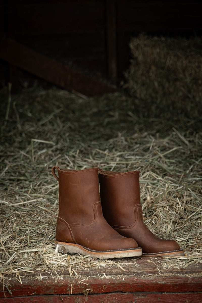 Brown wellington chore boot in a barn. The perfect boot to keep by your door