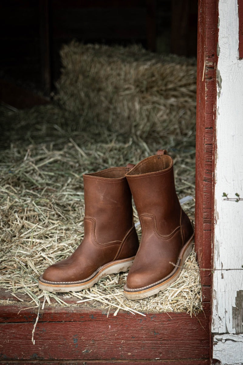 Brown wellington chore boot in a barn. The perfect boot to keep by your door
