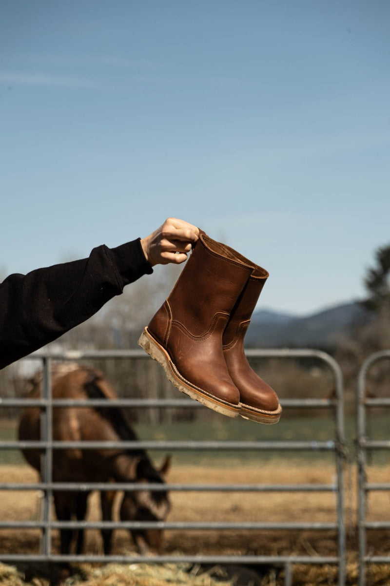 Brown wellington chore boot in a barn. The perfect boot to keep by your door