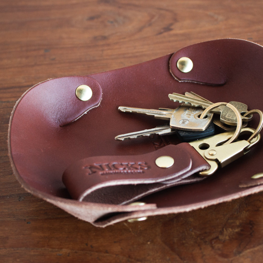Brown leather key holder with keys on a wooden surface