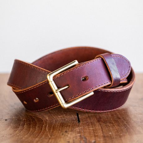 Cypress Raisin Cherry Heritage belt sitting on wooden crate in front of white backdrop