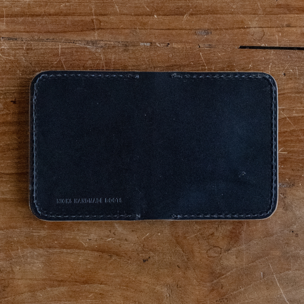 Black calf leather wallet with perimeter stitching laid open flat stamped with Nicks Handmade Boots
