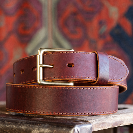 Cypress Raisin Cherry Heritage belt sitting on wooden crate in front of red backdrop