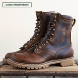 A pair of distressed brown leather lace-up boots with tan soles and brass eyelets, displayed on a rustic wooden surface against a light background. A text label in the top left reads 'LEATHER: PREDATOR ORANGE'.