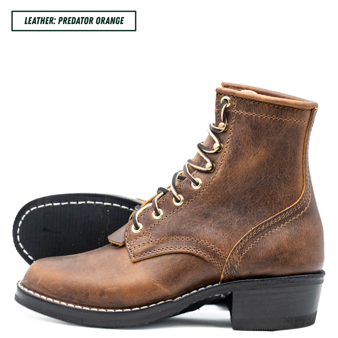 A brown distressed leather lace-up ankle boot with gold-toned eyelets and a black block heel, shown on a white background with a second boot showing the black sole behind it. A text label in the top left reads 'LEATHER: PREDATOR ORANGE'.