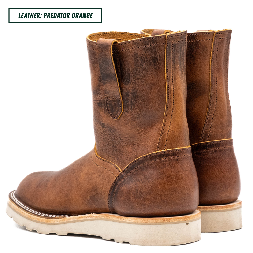 A pair of mid-calf western boots in distressed brown leather, shown from a three-quarter rear angle on a white background. A text label in the top-left corner reads 'LEATHER: PREDATOR ORANGE'.