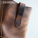 Close-up of a brown leather boot or shoe showing the upper side, stitching, and a pull strap tab, with text in the corner reading 'LEATHER: PREDATOR ORANGE'.