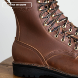 Close-up of a brown leather lace-up work boot with gold-toned metal eyelets and a black sole, shown on a wooden surface against a light background. A text box in the top left reads 'LEATHER: 1964 BROWN'.
