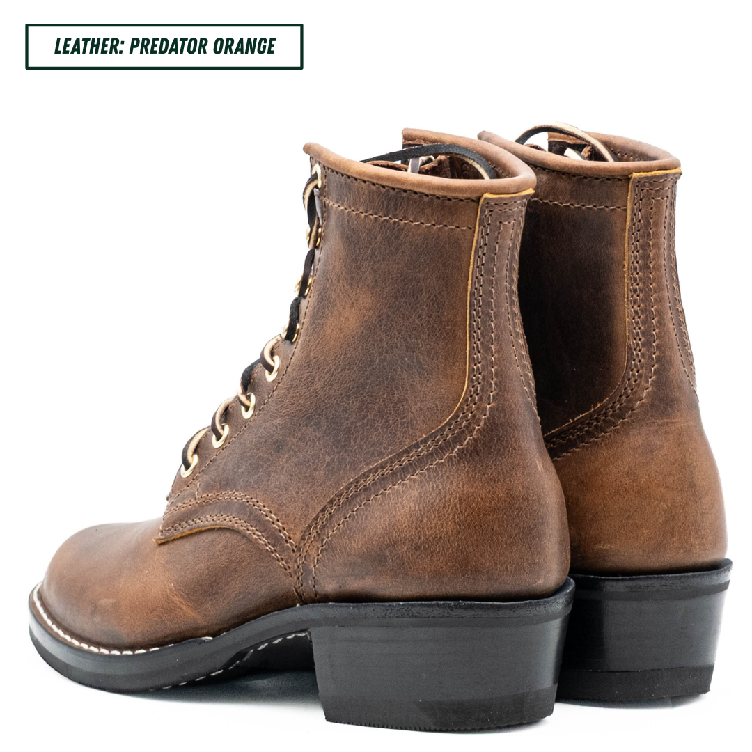 A pair of distressed brown leather lace-up ankle boots with black stacked heels, shown from a three-quarters angle on a white background. A text label in the top-left corner reads 'LEATHER: PREDATOR ORANGE'.