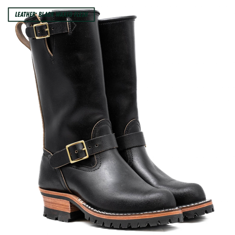 Pair of black leather boots with buckles on a white background