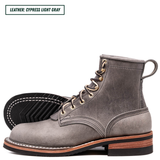 A pair of suede lace-up ankle boots in Cypress Light Gray with one boot standing upright and the other lying on its side to show the treaded sole. A text label in the top left reads 'LEATHER: CYPRESS LIGHT GRAY'.