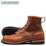 A pair of leather lace-up boots in a rich brown color, with one boot standing upright and the other lying on its side to show the black treaded sole. A text label in the top left corner reads 'LEATHER: SHACKLETON TOBACCO'.