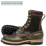 A pair of leather lace-up boots in dark olive green with gold-toned metal eyelets and a black lug sole, shown on a white background with a text label reading 'LEATHER:SHACKLETON GREENER PASTURES'.