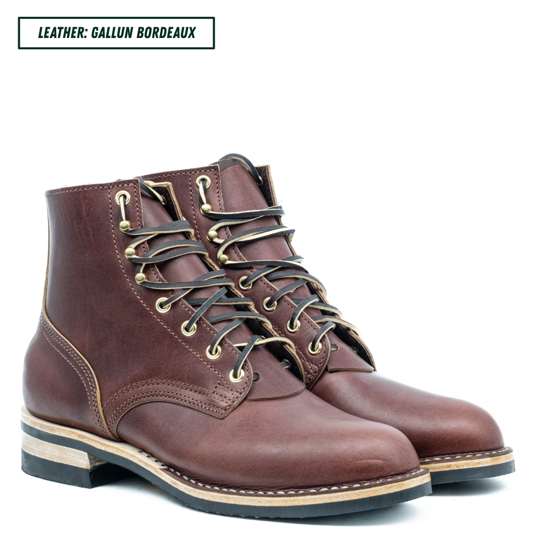 A pair of dark brown leather lace-up ankle boots with brass eyelets and black laces, shown on a white background with a text label in the top left corner.