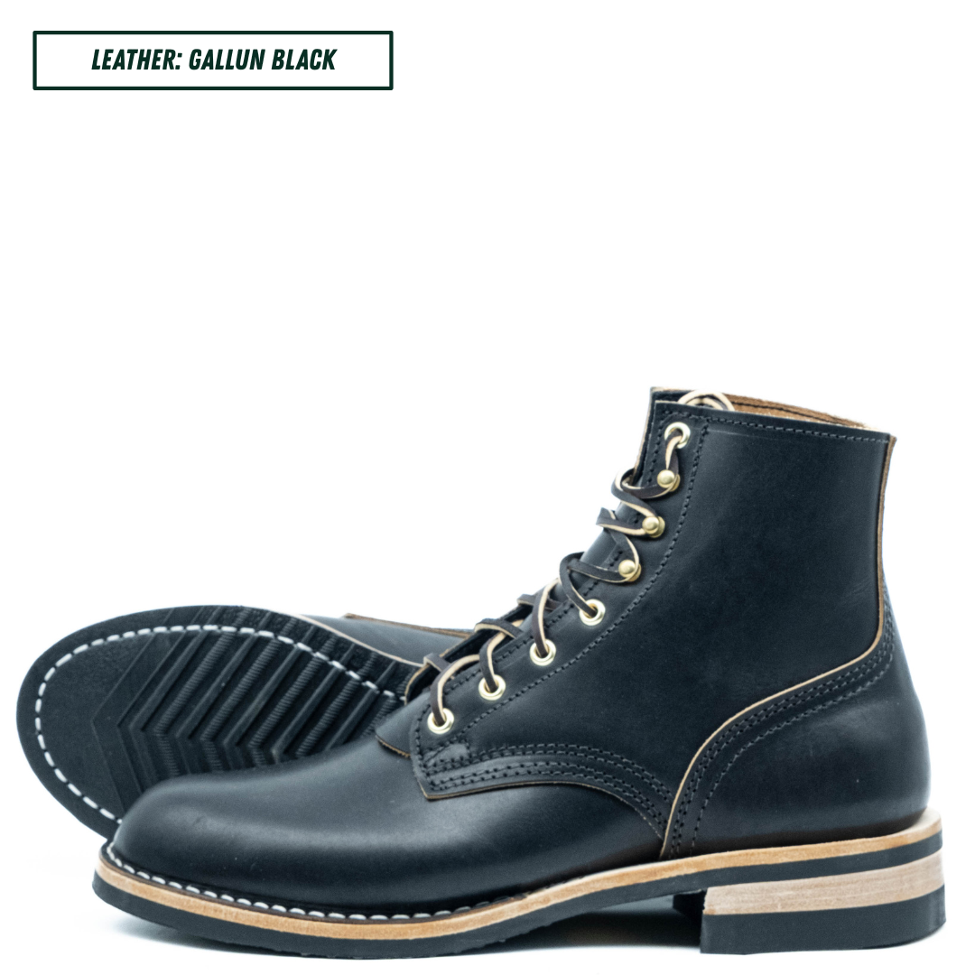 A pair of dark navy leather lace-up boots shown on a white background, with one boot standing upright and the other lying on its side to display the sole. A text label in the top left reads 'LEATHER: GALLUN BLACK'.
