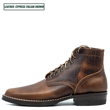 A single distressed leather ankle boot in a rich brown shade, featuring tan laces, metal eyelets, and white contrast stitching. A text overlay in the top left corner reads 'LEATHER: CYPRESS ITALIAN BROWN'.
