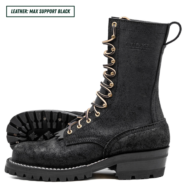 A pair of black leather lace-up boots with gold-tone eyelets and laces, shown on a white background with one boot standing upright and the other lying on its side to display the sole. A text label in the top-left corner reads 'LEATHER: MAX SUPPORT BLACK'.