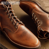 A close-up of a pair of leather lace-up boots in a warm brown shade, with white contrast stitching and metal eyelets. Text in the top-left corner reads 'LEATHER: CYPRESS ITALIAN BROWN'.