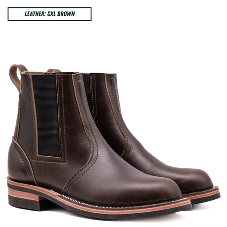 A pair of dark brown leather Chelsea boots with black elastic side panels, shown on a white background with a text label in the top left corner that reads 'LEATHER: CXL BROWN'.