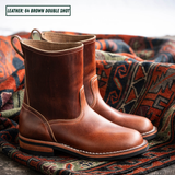 A pair of brown leather double-shot boots resting on a patterned woven rug, with a text overlay in the top left reading 'LEATHER: 64 BROWN DOUBLE SHOT'.