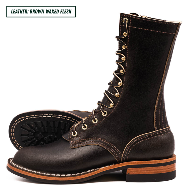 A pair of dark brown waxed leather lace-up boots with gold-tone eyelets and white contrast stitching, shown on a white background with a text label in the top-left corner.