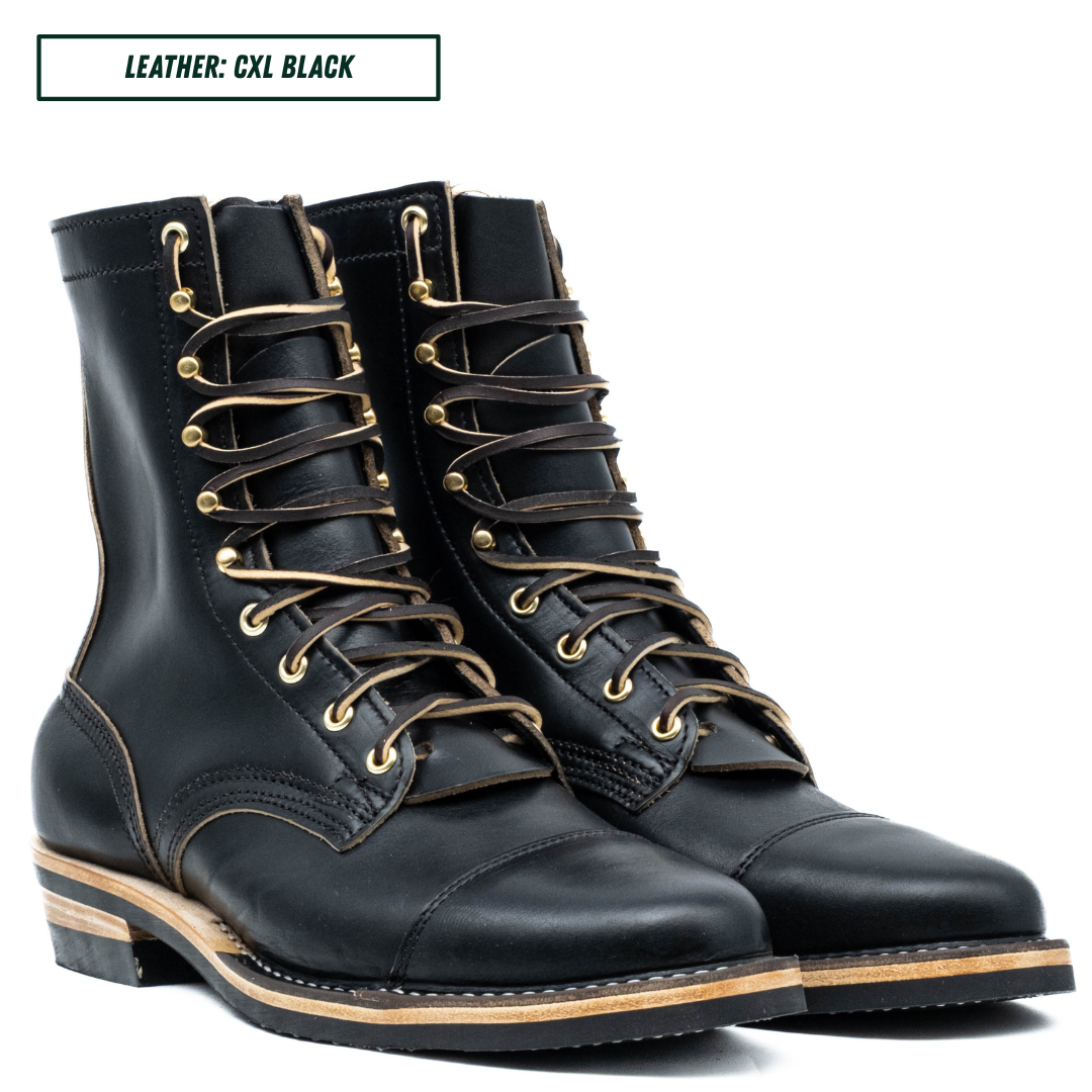 A pair of black leather lace-up boots with tan laces and brass eyelets, shown on a white background with a text label reading 'LEATHER: CXL BLACK'.