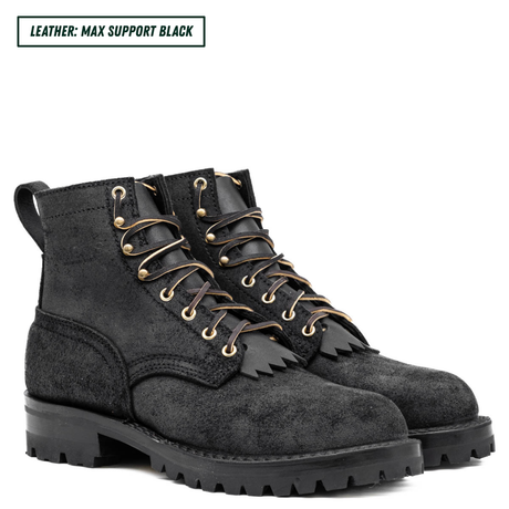 Pair of black suede boots with gold laces on a white background