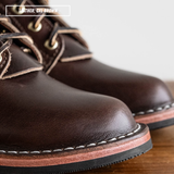 A close-up of a pair of dark brown leather lace-up boots on a wooden surface with a white background. A text overlay in the top left reads 'LEATHER: CXL BROWN'.