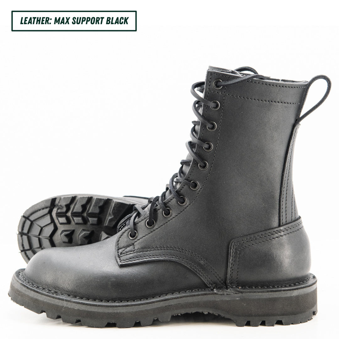 A pair of black leather lace-up combat boots shown on a white background, with one boot standing upright and the other lying on its side to display the treaded sole. A text label in the top-left corner reads 'LEATHER: MAX SUPPORT BLACK'.