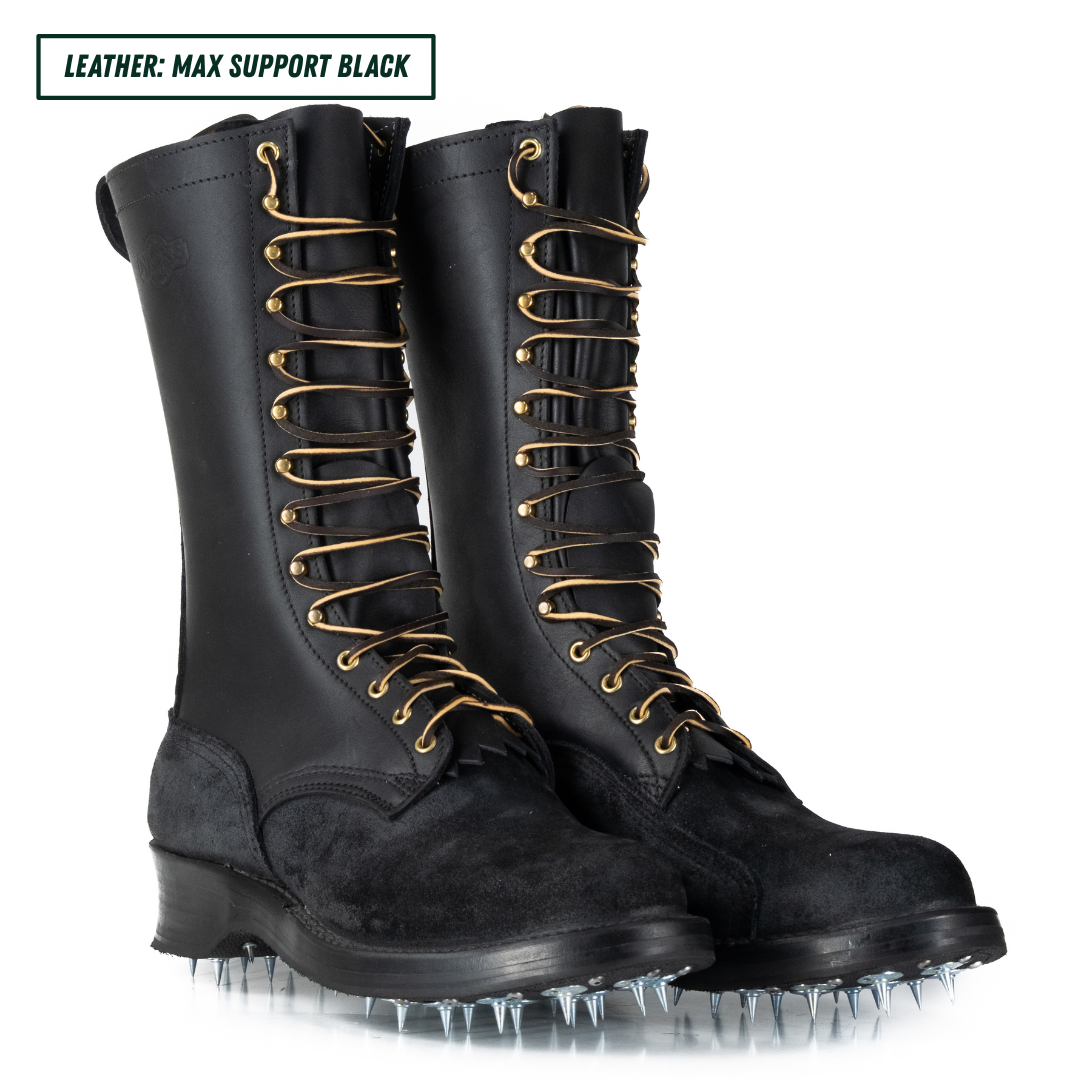 A pair of tall black leather combat boots with gold laces and metal spikes on the soles, shown on a white background with a text label in the top left corner.