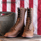 A pair of mid-calf lace-up boots in a weathered brown leather, styled on a rustic wooden surface with a vintage metal case and the American flag in the background. A text overlay in the top left reads 'LEATHER: WEATHERSHIELD BROWN'.